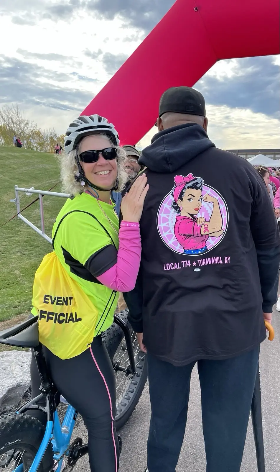 One of our event marshals posing for a picture next to a man wearing a breast cancer awareness hoodie